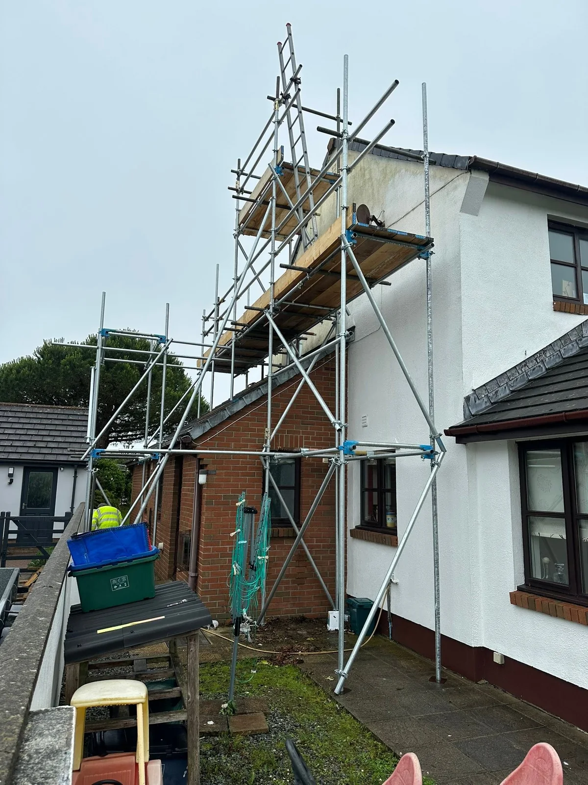 Scaffold providing side and chimney access to a house